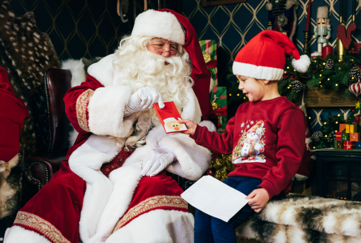 Hyde Park Winter Wonderland Christmas 2026 guide: a young child receiving a gift from Santa in his grotto