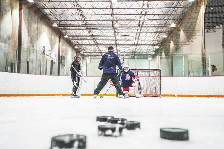 Hockey players with pucks in the foreground