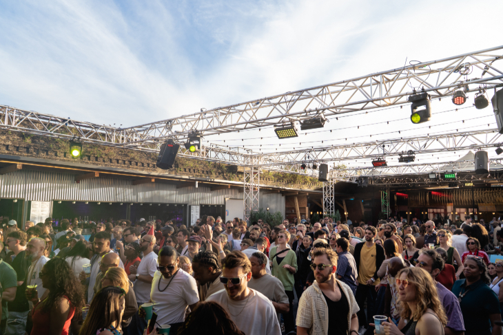 Things to do in London this weekend: a festival-style crowd, some with drinks in hand, in an open-air courtyard
