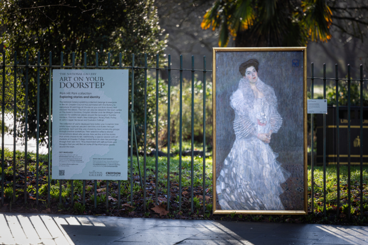 Things to do in London today: a painting mounted on a black metal railing, next to an information panel from the National Gallery