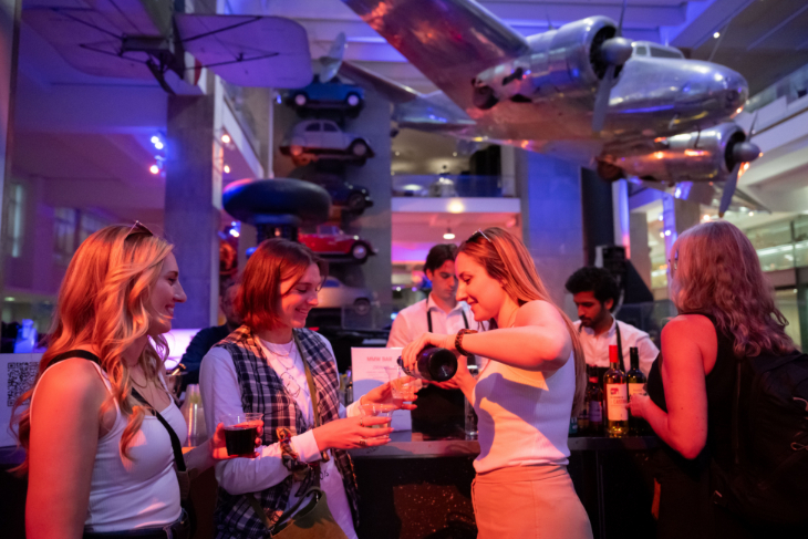 Things to do in London today: people holding drinks beneath a plane suspended from the ceiling at a Science Museum Late