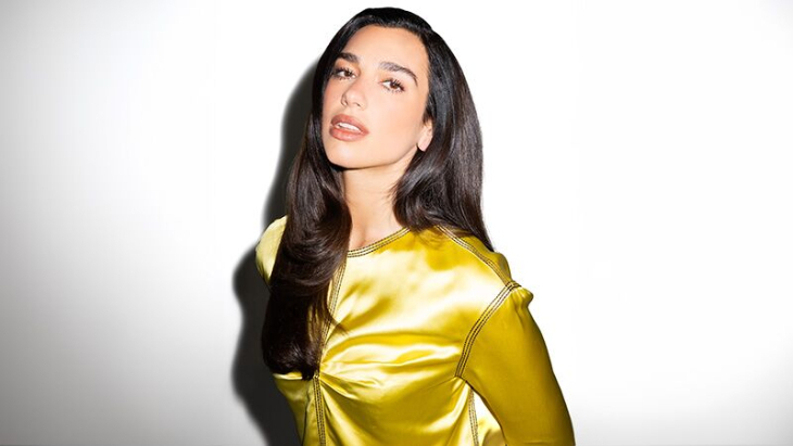 Things to do in London in October 2026: Dua Lipa with long straight brown hair, wearing a satin yellow shirt.