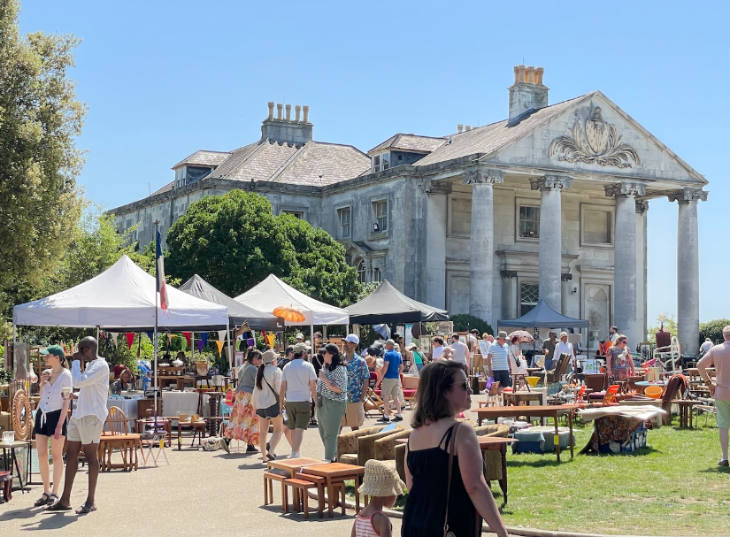 Things to do in London August bank holiday weekend 2026: people browsing stalls in front of a mansion house in the sun