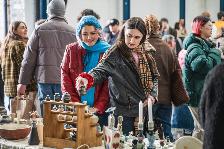 Things to do in London this weekend: people browsing a ceramics stall at an indoor market