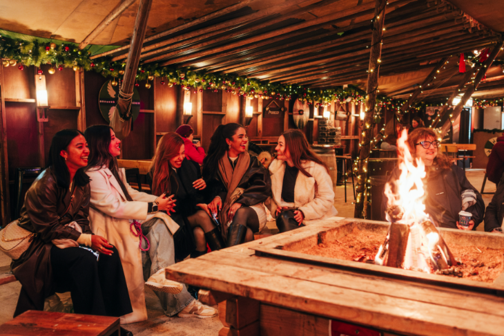 Hyde Park Winter Wonderland Christmas 2026 guide: a group of people sitting around a fire pit