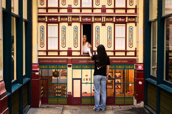 A woman being served a tiny back through a window