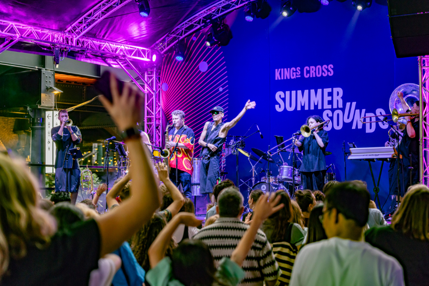 Crowds watching musicians perform on a festival stage