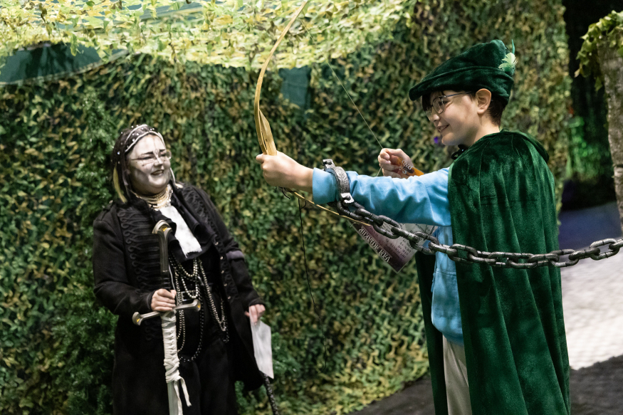 October 2026 half term in London: A boy in a green costume using an archery bow and arrow