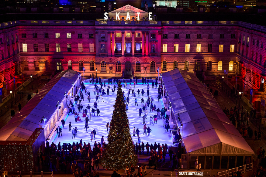 Christmas 2026 ice rinks in London: people skating on an ice rink in the courtyard at Somerset House, in front of a large Christmas tree