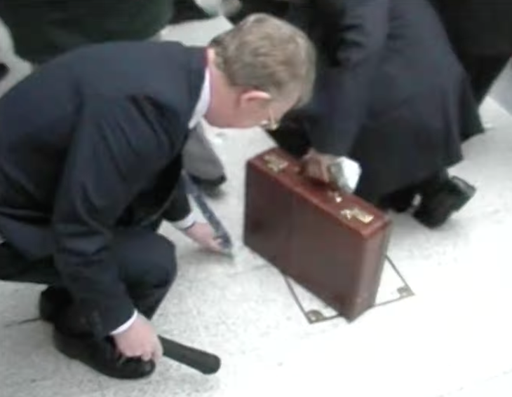 A man bends down to pick up cash