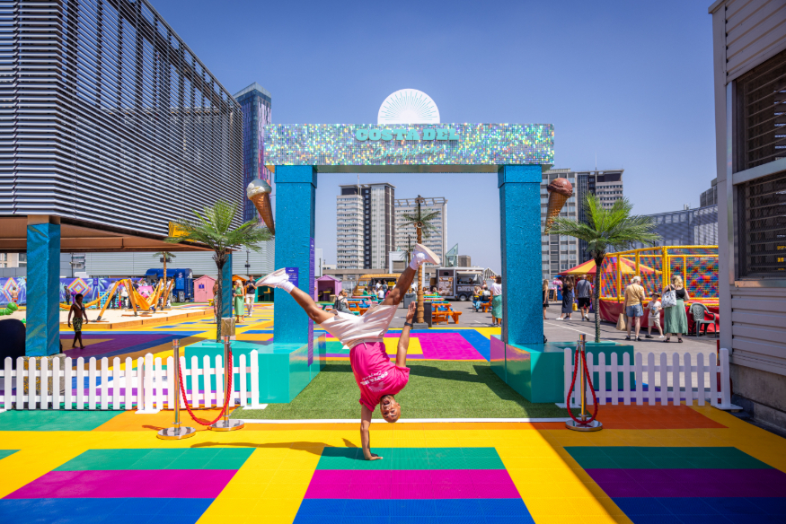 Things to do in London today: a person doing a handstand at the colourful entrance to Costa del croydon