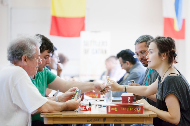 Things to do in London this weekend: people sitting opposite each other across a wooden table playing tabletop games