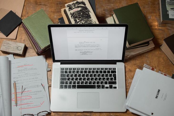 A writer's desk with laptop and notes