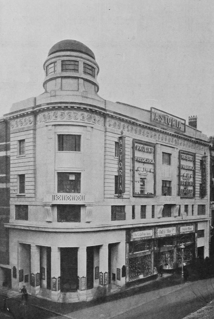 A black and white vintage photograph of the Astoria cinema and ballroom, a grand Art Deco building with a rounded corner tower topped by a dome. Large posters on the facade advertise Pauline Frederick in 