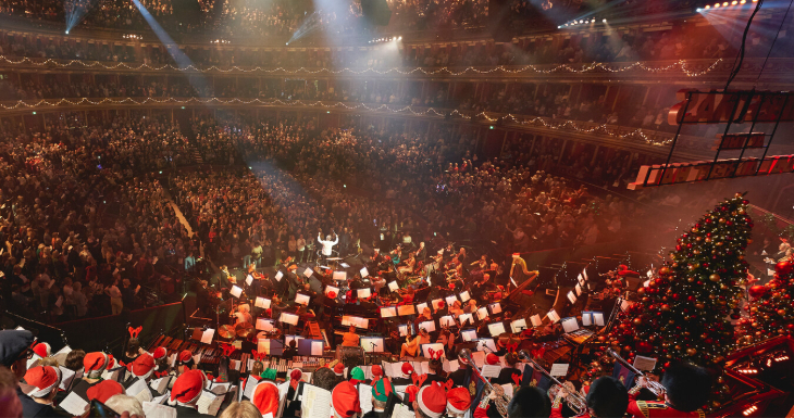 Christmas carol concerts London 2026: a band performing in festive hats inside a packed Royal Albert Hall