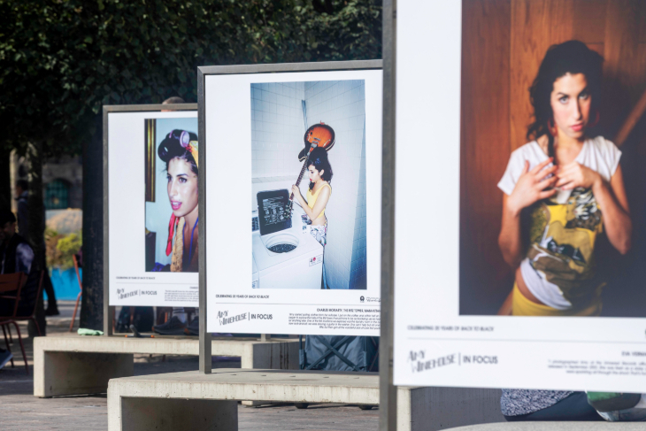 Three large photos of Amy Winehouse on display in an outdoor exhibition