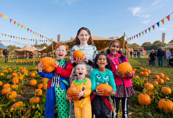 Pumpkin picking farms and patches near London 2026: a group of five children holding pumpkins and smiling for a photo in a pumpkin field