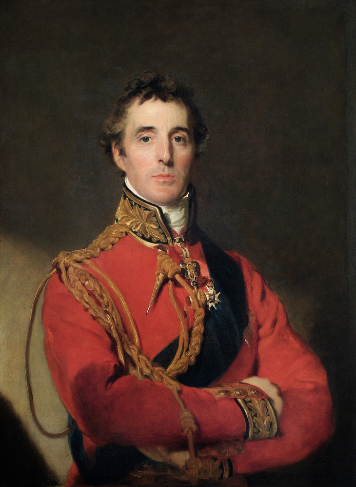 A waist-up oil portrait of Arthur Wellesley, 1st Duke of Wellington, wearing a red military uniform with gold braided aiguillettes, a dark blue sash, and various medals. He has short, dark curly hair and a serious expression, posed with his arms crossed against a dark, neutral background.