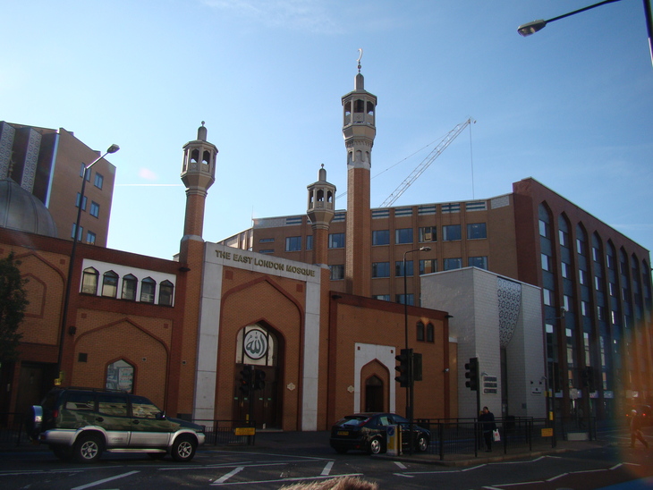 Free things to do this week: The East London Mosque, a brick building with three minarets and a large arched entrance, stands on a city street under a clear blue sky.