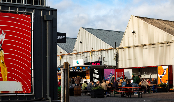People sitting at picnic tables outside a brewery