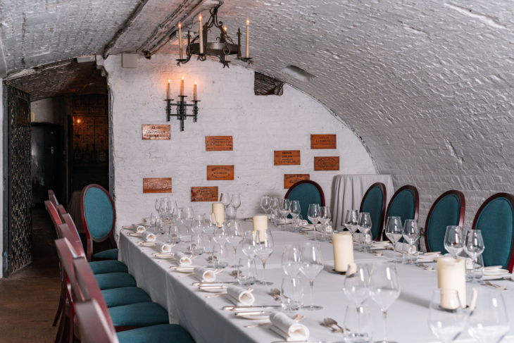 Things to do in London today:  a table laid out for a formal dinner, beneath the whitewashed vaulted ceiling of what appears to be a wine cellar