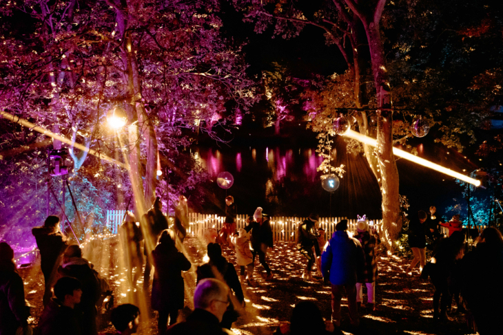 Winter light trails festivals near London Christmas 2026: people dancing beneath disco balls in trees