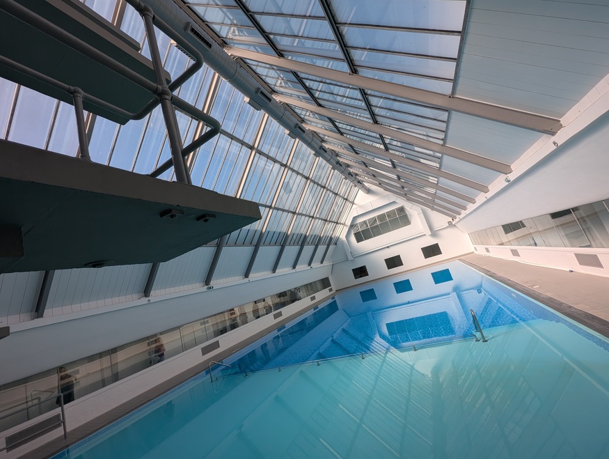 A swimming pool with triangular glass ceiling