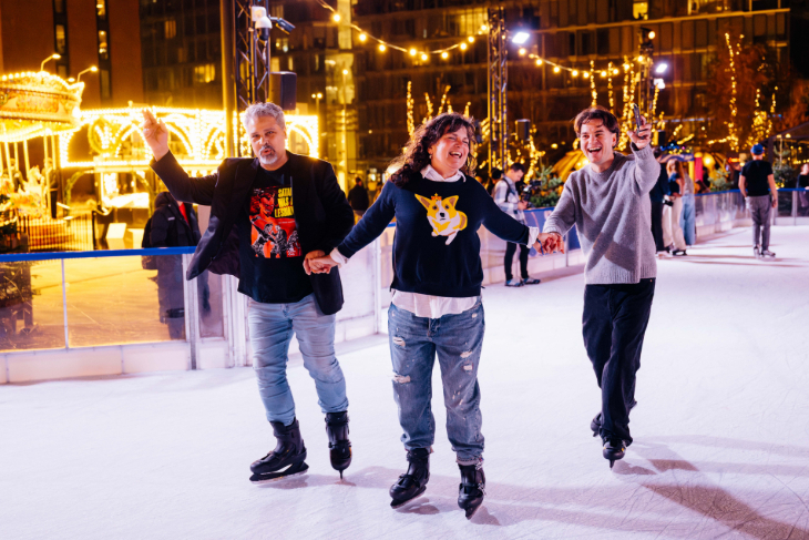 Things to do in London in December 2026: three people holding hands and ice skating against a backdrop of fairy lights