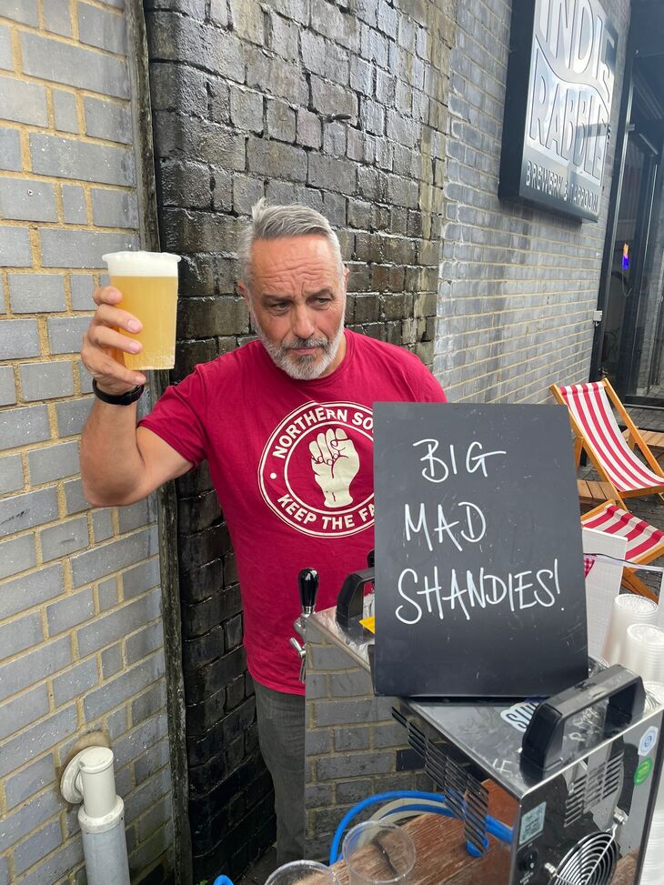 A bearded man selling shandies
