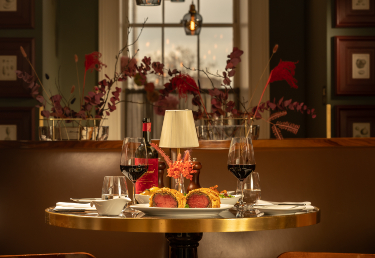 London restaurants on Christmas Day 2026: a table in a high-end restaurant with two glasses of red wine and a plate of beef wellington