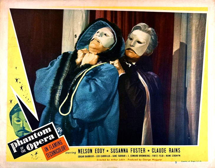 A vintage lobby card for the 1943 film "Phantom of the Opera" shows a man in a blue hooded coat being strangled from behind by a man in a white mask and dark cape. The poster features the title in a stylized font and lists stars Nelson Eddy, Susanna Foster, and Claude Rains.