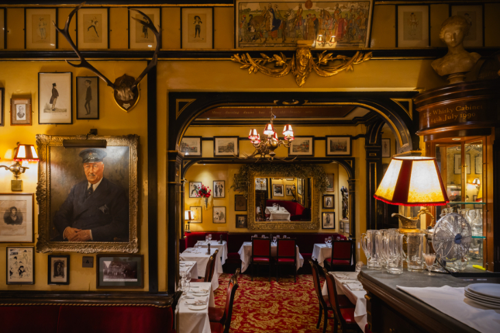 The interior of Rules, with walls covered in framed pictures, as well as antlers and other curiosities
