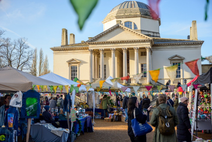 Things to do in London this weekend: people browsing market stalls beneath colourful bunting in front of Chiswick House