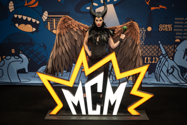 Things to do in London today: a woman in fancy dress at Comic Con, wearing feathered wings and a pair of horns - possibly dresed as Maleficient