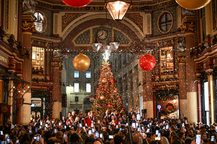 London Christmas lights 2026 switch on dates: fake snow falling inside Leadenhall Market as crowds gather around a Christmas tree