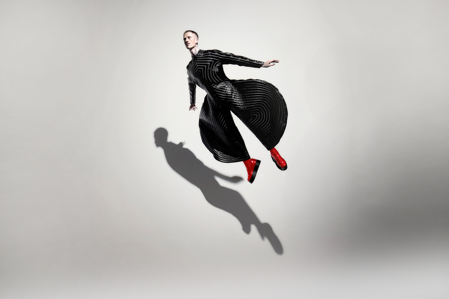 A dancer in David Bowie style suit with flaired trousers