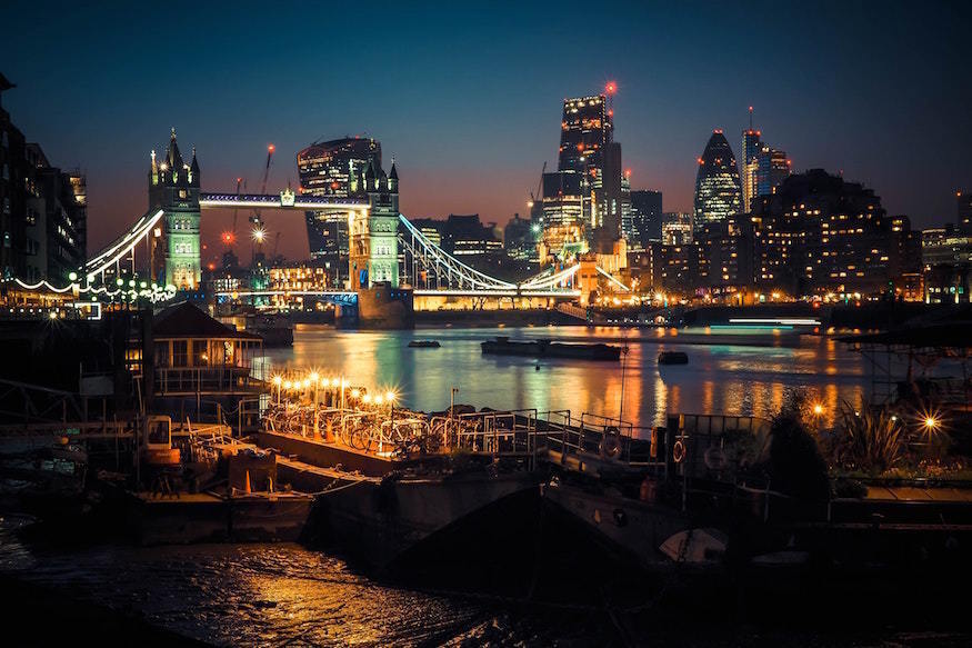 London landmarks including Tower Bridge and the City skyscrapers illuminated in the dark